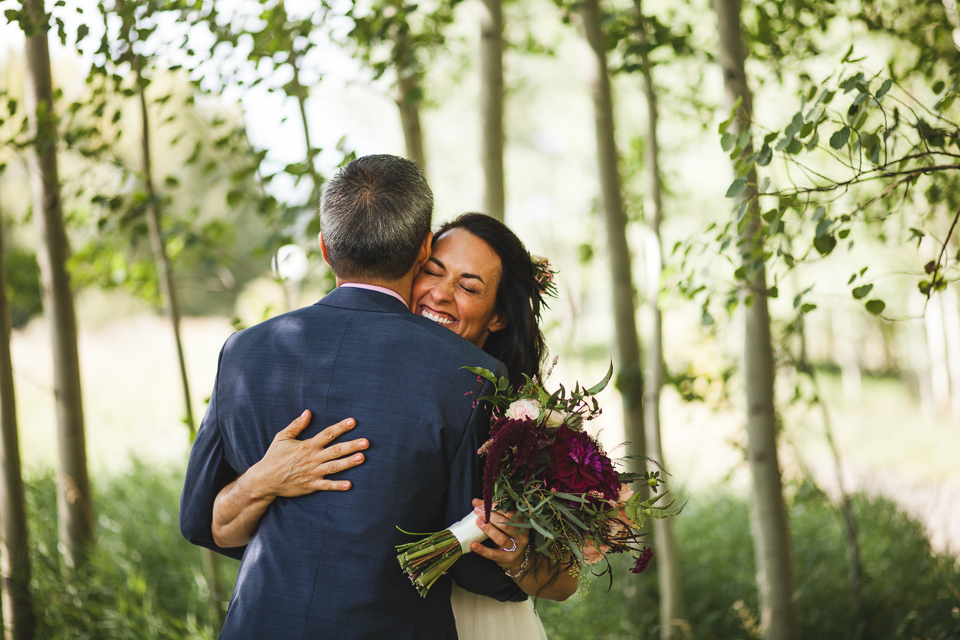 aspen colorado wedding bride smiling hugging groom