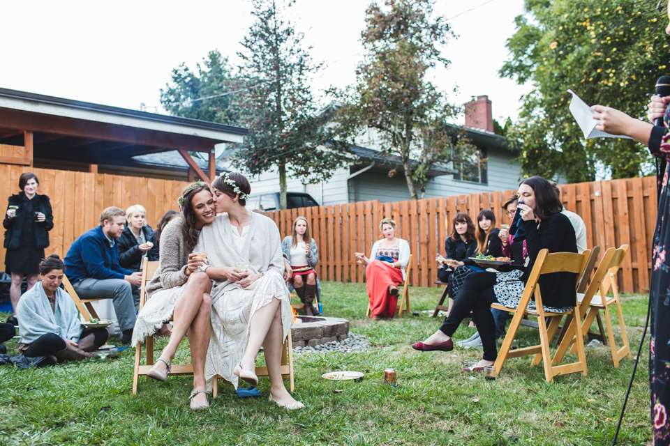 brides listening to toast at backyard same sex portland oregon wedding