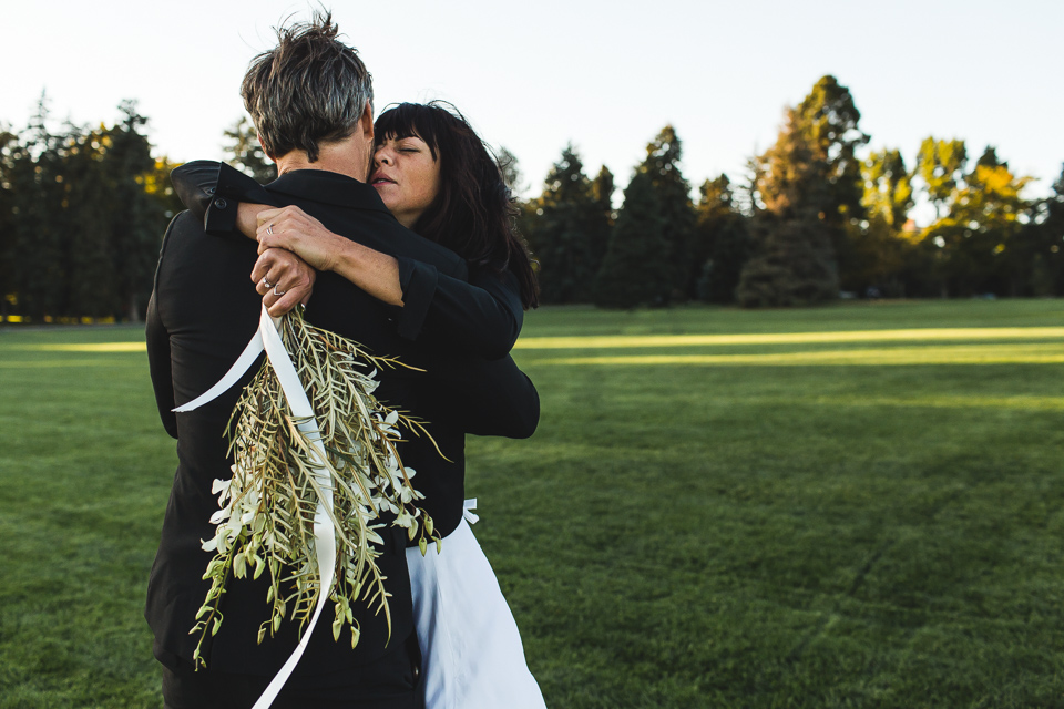 bride and groom cuddling in congress park in denver colorado on wedding day