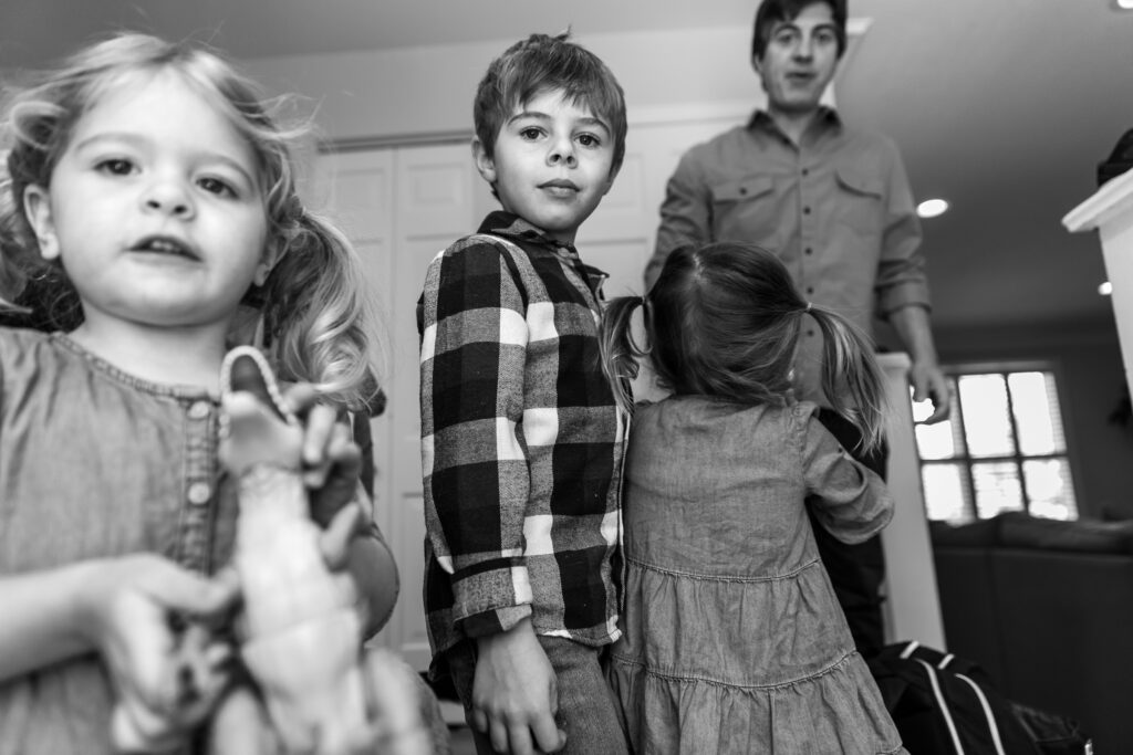 Family getting ready to leave the house in a black and white image during in home session.